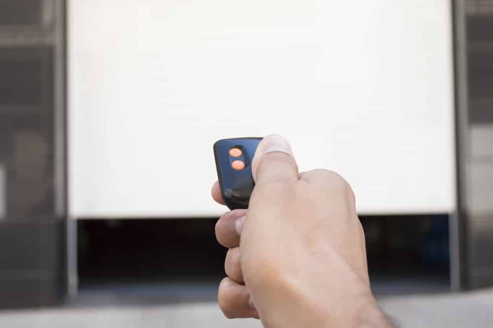 Hand,Pressing,A,Remote,Control,With,The,Door,Open Garage door opener